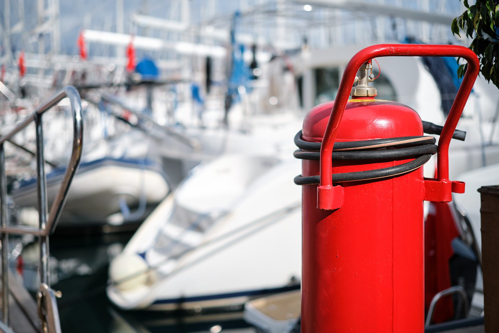 Home fire extinguisher close up on the mooring of the yacht club, blurred background. providing fire protection and safety prevention.