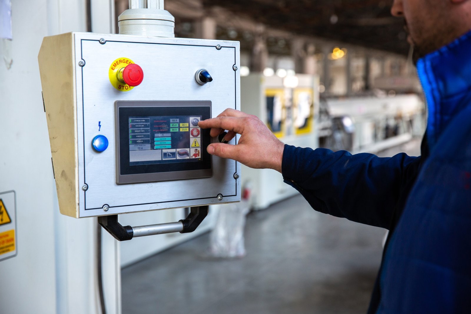 worker uses control panel factory scaled.jpg